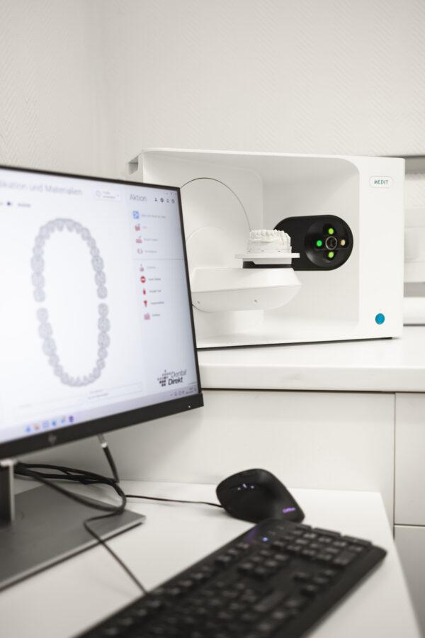 Digitaler Scanner im praxiseigenen Zahnlabor: Gebissmodell im Scanner, das digitale Kiefermodell auf dem Monitor